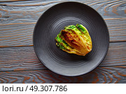 endive little Lettuce grilled with vinaigrette sauce on black plate. Стоковое фото, агентство Ingram Publishing / Фотобанк Лори