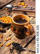 healthy tea with sea-buckthorn. teacup with healing berry tea with sea-buckthorn on retro background. Стоковое фото, агентство Ingram Publishing / Фотобанк Лори