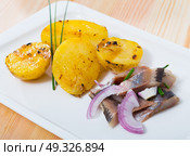 Slices of mild-cured herring with potatoes and onions served on plate. Стоковое фото, фотограф Яков Филимонов / Фотобанк Лори