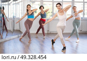 Smiling young woman enjoying vigorous dance at group class. Стоковое фото, фотограф Яков Филимонов / Фотобанк Лори