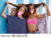 Best friends teen girls group bubble gum in a summer blue stripes background. Стоковое фото, агентство Ingram Publishing / Фотобанк Лори