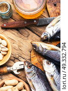 salted fish and beer. glass of beer, salted fish and nuts on a wooden table. Стоковое фото, агентство Ingram Publishing / Фотобанк Лори