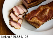 smoked pork ribs on white plate on wooden background. Стоковое фото, агентство Ingram Publishing / Фотобанк Лори