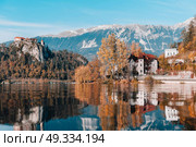 Lake Bled in the Alpine mountains in autumn under blue sky. Стоковое фото, агентство Ingram Publishing / Фотобанк Лори