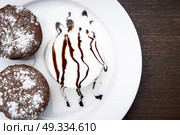 chocolate muffins with ice cream drizzled with chocolate topping. Стоковое фото, агентство Ingram Publishing / Фотобанк Лори