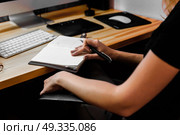 designer girl at work at the table draws on the tablet, close the keypad, printer, computer. Стоковое фото, агентство Ingram Publishing / Фотобанк Лори