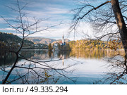 Lake Bled in the Alpine mountains in autumn under blue sky. Стоковое фото, агентство Ingram Publishing / Фотобанк Лори