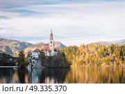 Lake Bled in the Alpine mountains in autumn under blue sky. Стоковое фото, агентство Ingram Publishing / Фотобанк Лори