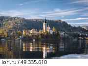 Lake Bled in the Alpine mountains in autumn under blue sky. Стоковое фото, агентство Ingram Publishing / Фотобанк Лори