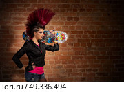 Young punk girl on brick wall background. Стоковое фото, агентство Ingram Publishing / Фотобанк Лори