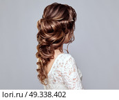 Brunette Woman with Long and shiny Curly Hair. Beautiful Model Lady with Curly Hairstyle. Care and Beauty Hair products. Care and Beauty of Hair. Стоковое фото, агентство Ingram Publishing / Фотобанк Лори