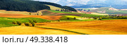 Spring tillage on hills panorama. Picturesque ploughland in a valley in Tatras mountains of Slovakia. Rural scene of cultivated land. . Стоковое фото, агентство Ingram Publishing / Фотобанк Лори