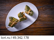 Zongzi Glutinous sticky Rice Dumplings recipe wrap with bamboo leaves asian food. Стоковое фото, агентство Ingram Publishing / Фотобанк Лори