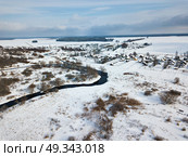 Winter rural landscape. Village and fields covered by snow. Aerial view of small river bends . Стоковое фото, агентство Ingram Publishing / Фотобанк Лори