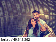 Tourist couple relaxed inside a beach parasol in summer vacation. Стоковое фото, агентство Ingram Publishing / Фотобанк Лори