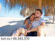 young couple hug in a beach under parasol at summer. Стоковое фото, агентство Ingram Publishing / Фотобанк Лори