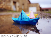 Color paper boats in a puddle . Стоковое фото, агентство Ingram Publishing / Фотобанк Лори