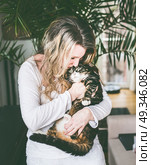 Pretty women in living room holds cat in her arms and cuddle. Стоковое фото, агентство Ingram Publishing / Фотобанк Лори