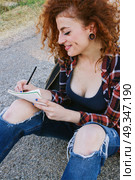 Young redhead student writing in her notebook . Стоковое фото, агентство Ingram Publishing / Фотобанк Лори