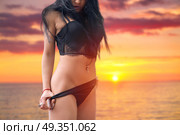 girl takes off shorts on the beach at sunset. girl takes off shorts on the beach. Стоковое фото, агентство Ingram Publishing / Фотобанк Лори