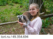 Kid girl having fun with ring tailed lemur animal. Kid girl having fun with ring tailed lemur animal outdoor. Стоковое фото, агентство Ingram Publishing / Фотобанк Лори