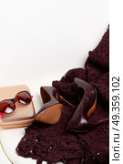 Hight heel shoes for Christmas party. Hight heel elegant shoes, bag, sunglasses and laced dress in chair. Стоковое фото, агентство Ingram Publishing / Фотобанк Лори