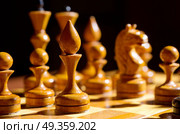 Chessboard with figures on dark background. Chessboard with figures. Стоковое фото, агентство Ingram Publishing / Фотобанк Лори