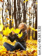 The laughing girl throws autumn leaves in park. Seasons. Стоковое фото, агентство Ingram Publishing / Фотобанк Лори