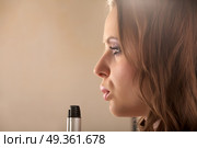 The girl with a curly hairdress blows on a tip of hairdresser?s twisting nippers. The curly beauty . Стоковое фото, агентство Ingram Publishing / Фотобанк Лори