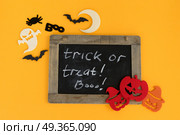 Colorful halloween scene. Trick and treat letters on blackboard with colorful halloween pumpkins, bats and ghoste. Стоковое фото, агентство Ingram Publishing / Фотобанк Лори
