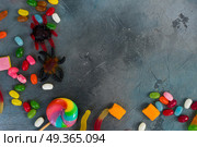 Colorful halloween candies on stone. Trick and treat - halloween scary candies on gray stone with copy space. Стоковое фото, агентство Ingram Publishing / Фотобанк Лори