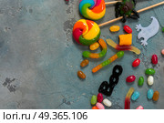 Colorful halloween candies on stone. Trick and treat - halloween candies border on stone with copy space. Стоковое фото, агентство Ingram Publishing / Фотобанк Лори