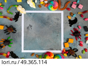 Colorful halloween candies on stone. Trick and treat - colorful halloween candies flat lay scene on stone with copy space. Стоковое фото, агентство Ingram Publishing / Фотобанк Лори