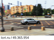 Grey Porsche Taycan Turbo S sports sedan on a city street in motion.  Racing along the highway, side view. Редакционное фото, фотограф Андрей Иванов / Фотобанк Лори