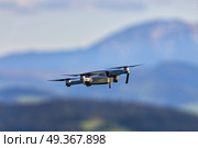 Drone with camera flying over mountain fields. Aerial photography and videography. Drone quad copter with high resolution digital camera in the air. Drone with camera flying over mountain fields. Aerial photograph. Стоковое фото, агентство Ingram Publishing / Фотобанк Лори