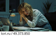 Уставшая женщина с ноутбуком и записями на рабочем месте / Tired woman with laptop and notes at the workplace. Стоковое AI-изображение, AI-художник Валерий Лукин / Фотобанк Лори