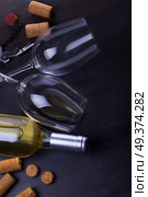 Bottle of white wine, corks and two wine glasse laying on table. Glass of red wine. Стоковое фото, агентство Ingram Publishing / Фотобанк Лори