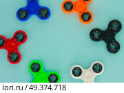 fidget spinners frame on blue background with copy space, popular relaxing toy, generic design. fidget spinner, popular relaxing toy, generic design. Стоковое фото, агентство Ingram Publishing / Фотобанк Лори