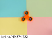 trendy fidget spinners - styled pop art flat lay scene with generic design orange spinner. fidget spinner, popular relaxing toy, generic design. Стоковое фото, агентство Ingram Publishing / Фотобанк Лори