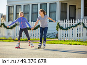 Teen girls group rolling skate in the street outdoor. Стоковое фото, агентство Ingram Publishing / Фотобанк Лори