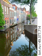 street with old houses over canal in Delft old town in Holland. Delft old town in Holland. Стоковое фото, агентство Ingram Publishing / Фотобанк Лори
