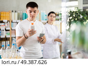 Guy buys emollient cream at pharmacy. Pharmacist offer help and similar product. Стоковое фото, фотограф Яков Филимонов / Фотобанк Лори