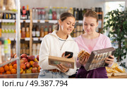 Young women scanning qr code for sweets. Стоковое фото, фотограф Яков Филимонов / Фотобанк Лори