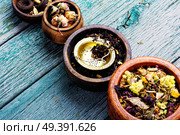 Mixture herbal floral tea in a wooden mortar. Various kind of leaf tea. Стоковое фото, агентство Ingram Publishing / Фотобанк Лори