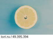 Fresh lemon citrus fruit slice on blue bakground, retro toned. Fresh lemon fruit. Стоковое фото, агентство Ingram Publishing / Фотобанк Лори
