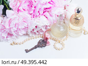 Skeleton key with peony flowers and fragrance bottles - love and wedding concept. Skeleton key with peony flowers. Стоковое фото, агентство Ingram Publishing / Фотобанк Лори