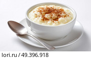 Creamy rice pudding served with cinnamon on a light surface. Сливочный рисовый пудинг с корицей на светлой поверхности. Стоковое AI-изображение, AI-художник Katsiaryna Repich / Фотобанк Лори