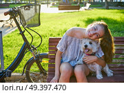 Girl with dog sitting in a park bench with turf grass background outdoor. Стоковое фото, агентство Ingram Publishing / Фотобанк Лори
