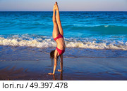 acrobatic gymnastics bikini girl in a beach blue shore at summer. Стоковое фото, агентство Ingram Publishing / Фотобанк Лори