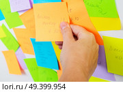 To do list - multicolored task notes with hand choosing one close up. To do lists. Стоковое фото, агентство Ingram Publishing / Фотобанк Лори
